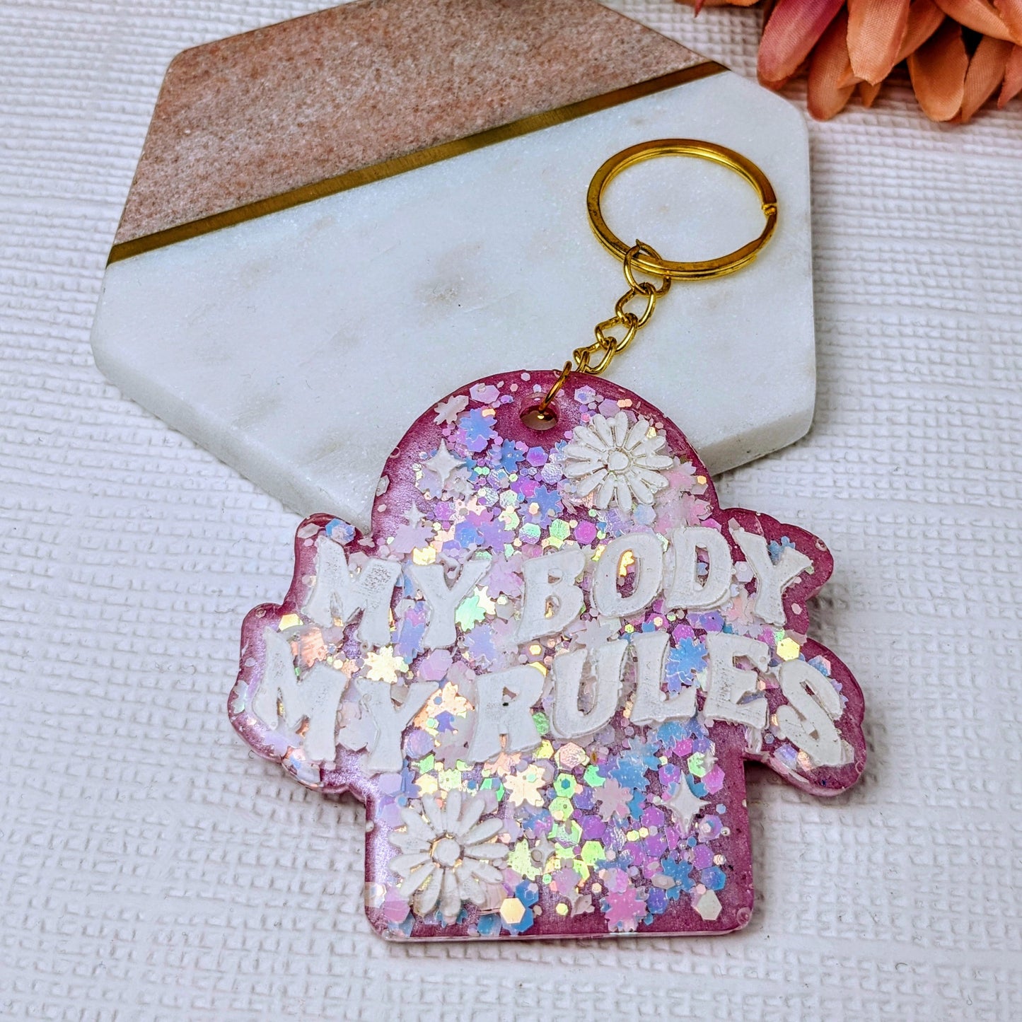 A keyring bag charm with pink glitter and a pink backing, featuring the text quote 'My Body My Rules' in white.