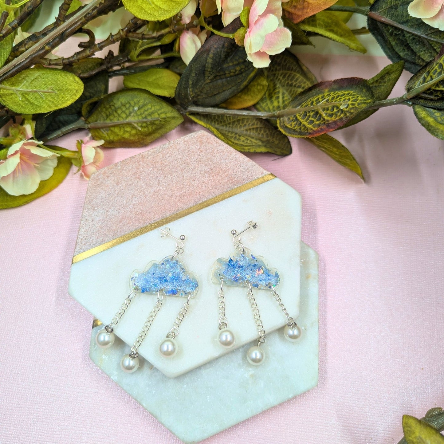 Pair of earrings on a decorative stand with floral background