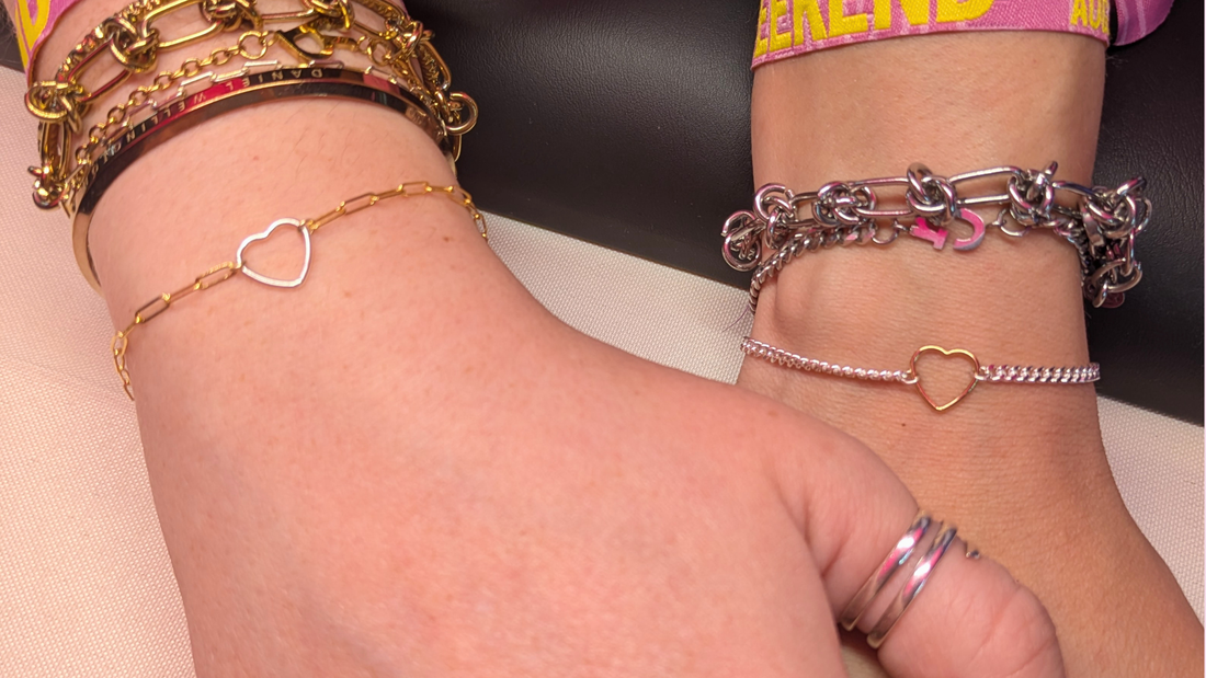 Two wrists wearing stacked permanent welded bracelets including a heart chain — Welded Bonds by Created By Lau, Shipley, West Yorkshire