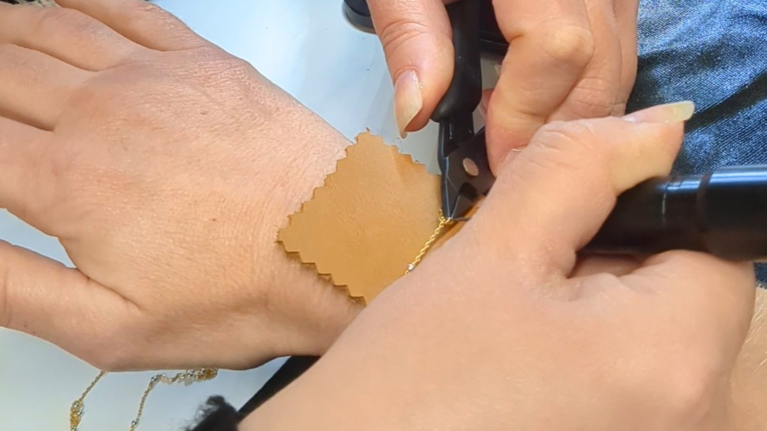 Jeweller welding a permanent gold chain bracelet onto a client's wrist at Welded Bonds by Created By Lau, Shipley