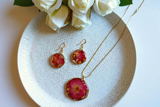 Bright flat lay of handmade resin statement necklace with pressed roses and gold leaf by Created By Lau — handmade jewellery made in Yorkshire