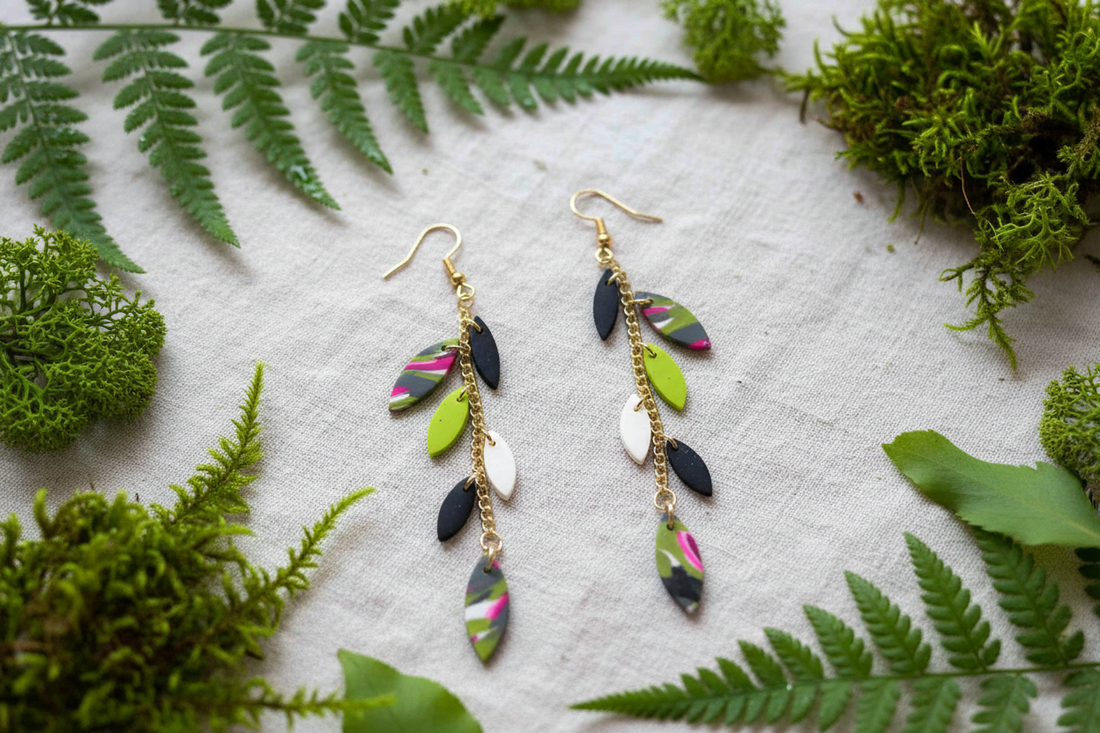 Handmade polymer clay 'Leah' chain drop earrings with leaf-shaped charms in green, black and pink, styled on natural moss and leaves — Created By Lau No Waste Collection, Yorkshire