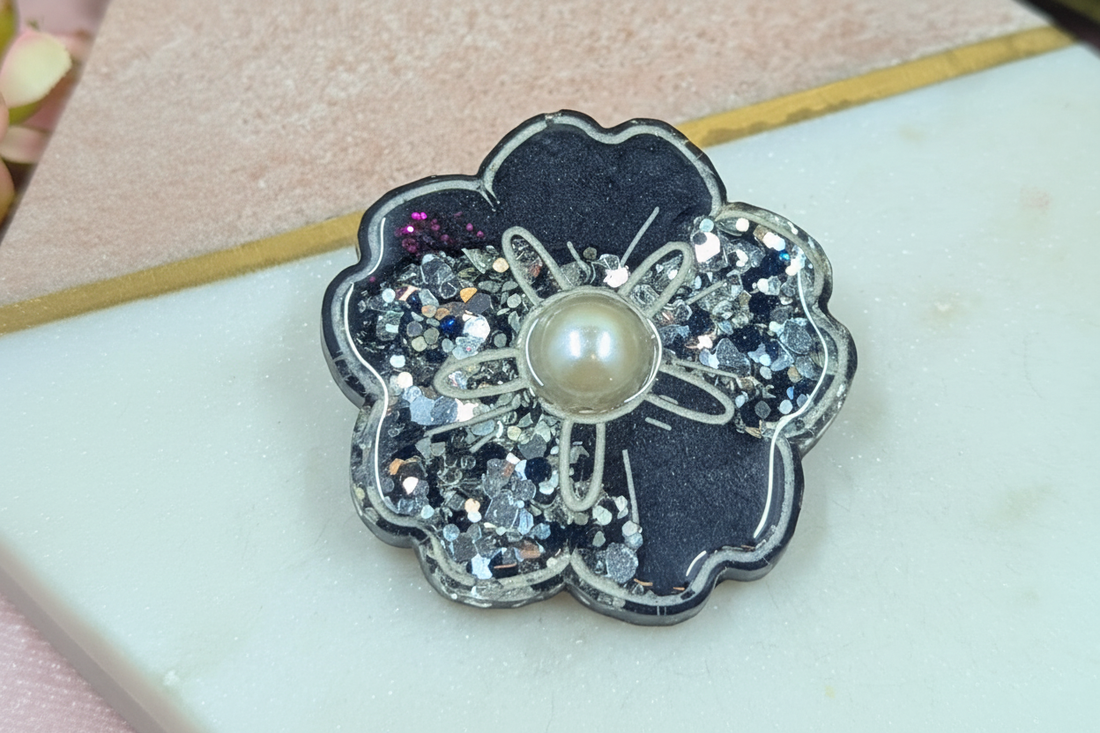 Handmade dark resin flower piece with pearl centre and glitter detail by Created By Lau — a timeless slow style accessory