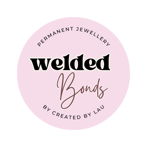 A circular pink badge with the text 'PERMANENT JEWELLERY welded Bonds BY CREATED BY LAU' in black and rose-gold lettering, on a white background.