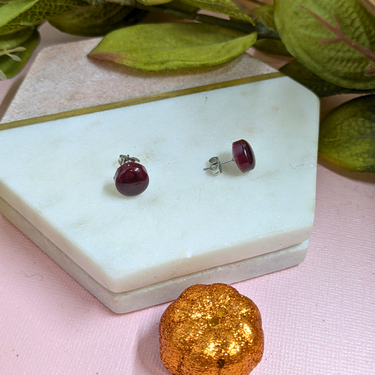 Pair of Bridget Blood Red handmade resin stud earrings on marble jewellery tray — rich opaque crimson resin with silver stud fittings, made in Yorkshire