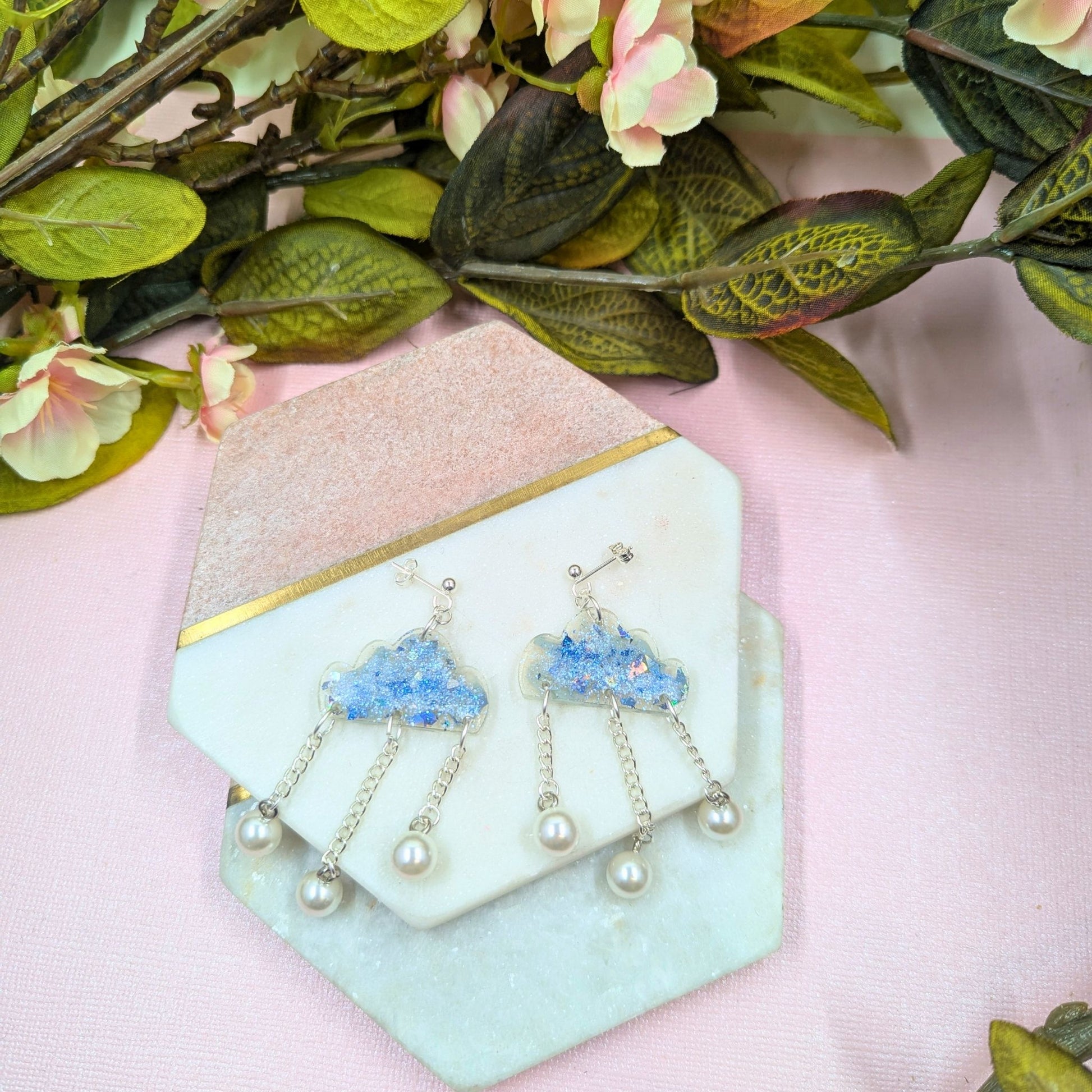 Pair of earrings on a decorative stand with floral background