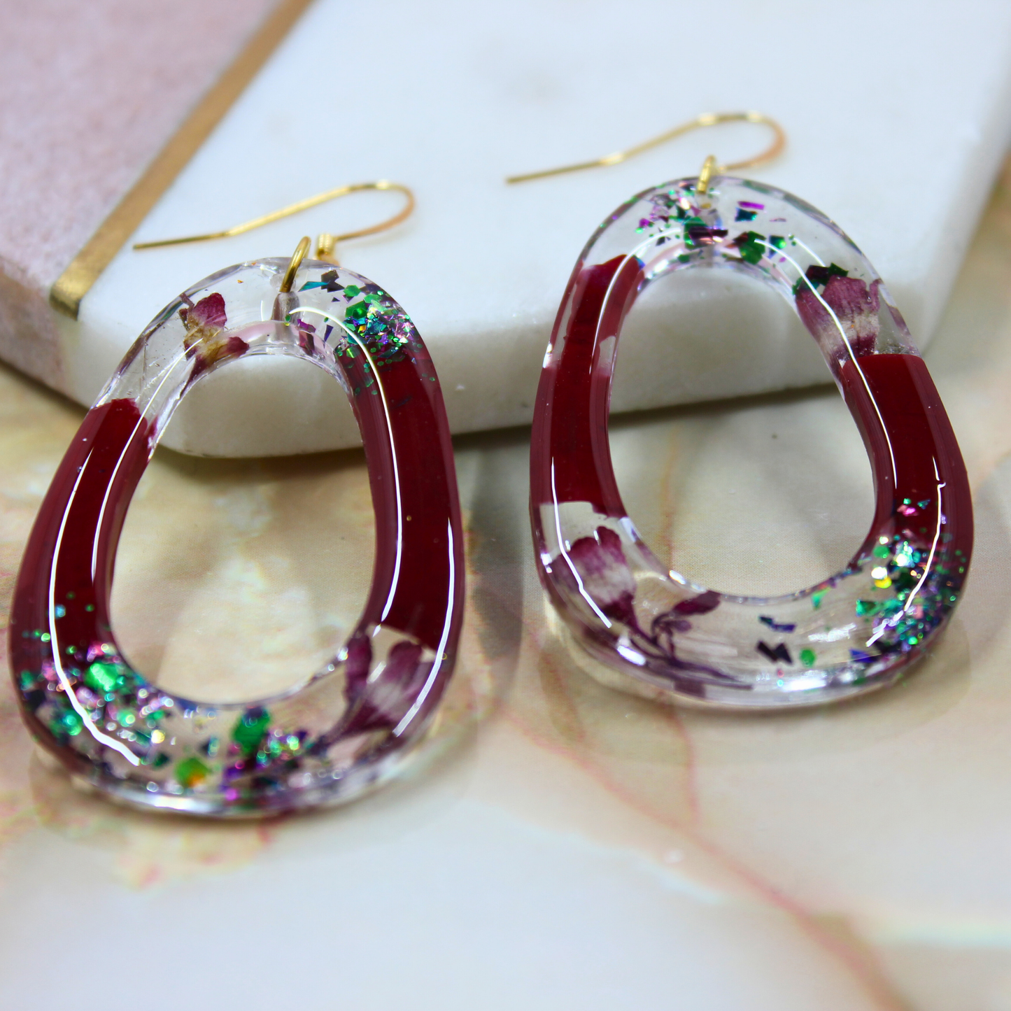 "Rowan" Mulberry Wine Glitter Oval Cutout Resin Dangle Earrings With Real Flowers