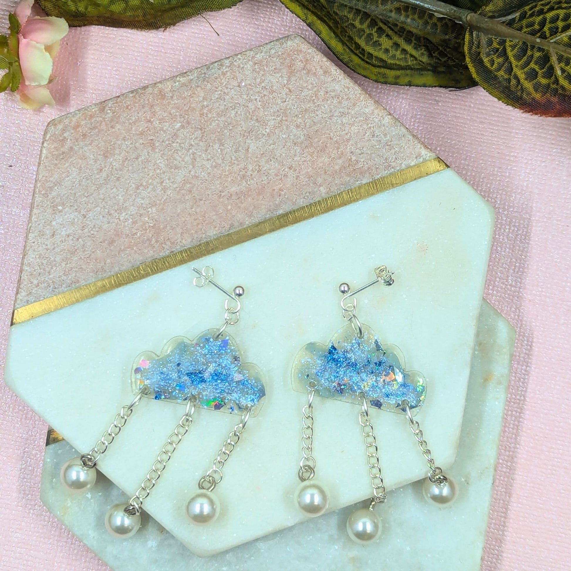 Close up of handmade cloud resin earrings showing mica and glitter shimmer detail with silver hardware