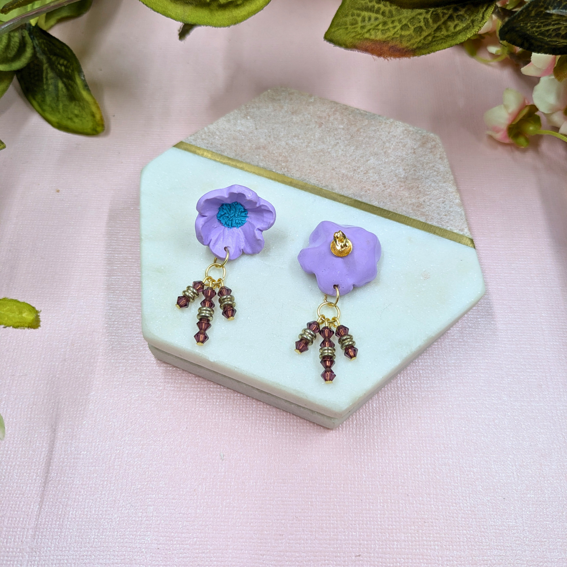 Angled view of Beatrix purple flower earrings showing depth and dimension