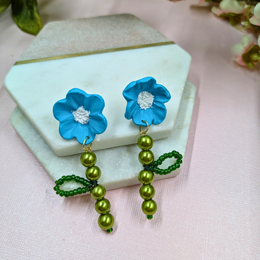 Front view of Fern handmade blue flower earrings with white centres